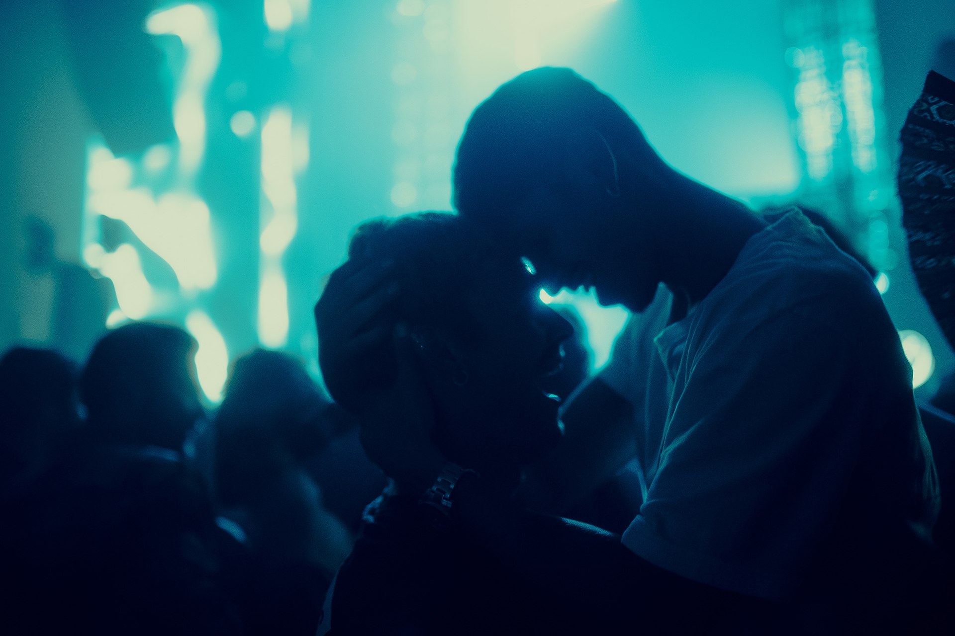 Silhouette of two people dancing with aqua lights in background at Heist Night Club